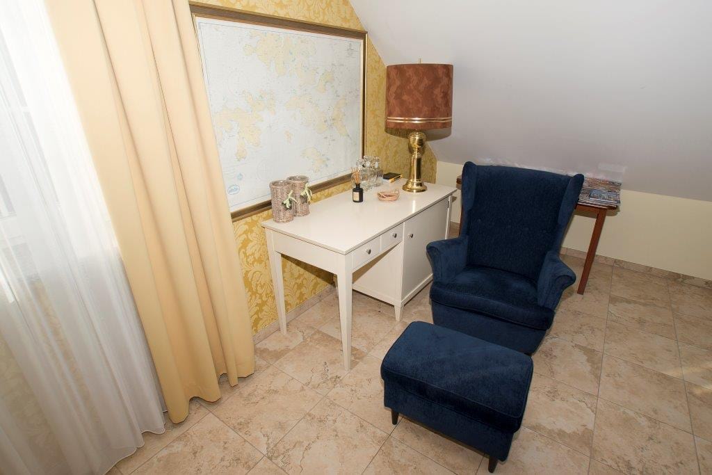 Niebieski fotel z pufą w salonie